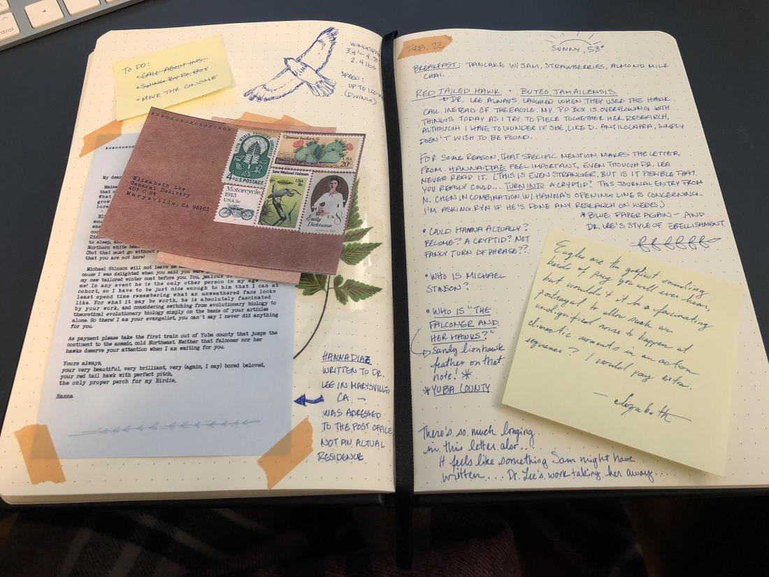 open pages of a journal with a letter and envelope, notes, and stickies