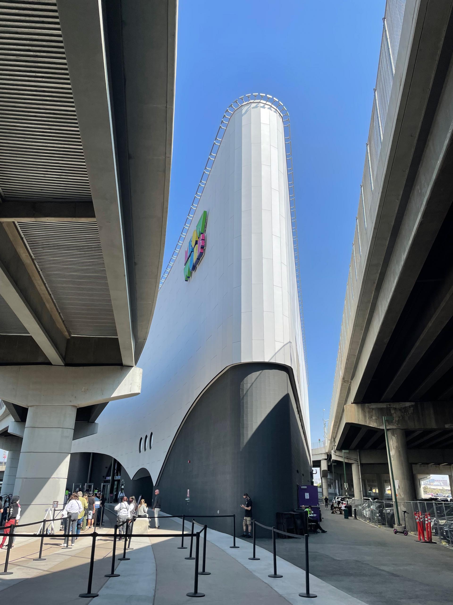 The uniquley shaped four story Meow Wolf building is nestled between to raised highways, at the convergence. 